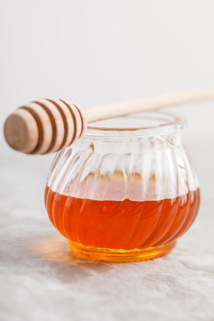 Close-up view of jar of honey on stone table.