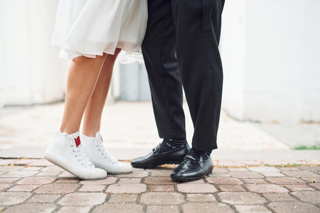 Close up view of legs on the ground Beautiful bride with his fiance is celebrating wedding outdoors