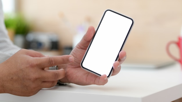 Close up view of male designer showing blank screen smartphone