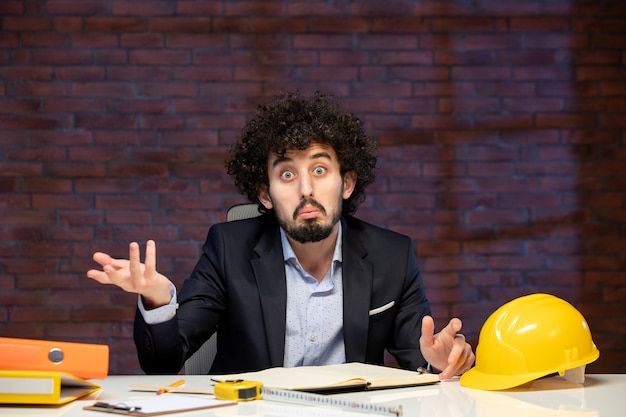 крупным планом мужчина инженер сидит за своим рабочим местом в костюме повестка дня план работы строитель архитектура корпоративный подрядчик бизнес работа