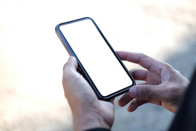 Крупным планом вид человека, держащего макет мобильного телефона с пустым экраномx9