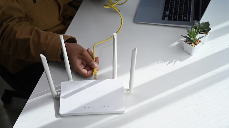 Photo close up view of man plugging in cable to wireless router. wireless internet concept.