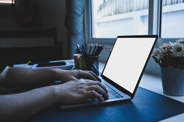 Close up view man sitting in home office and working with computer laptop