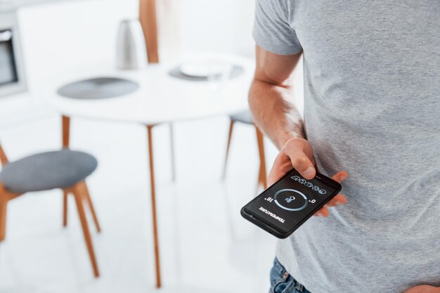 Close up view of man that is indoors controlling smart home technology