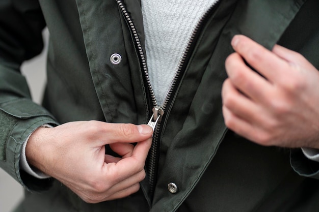 Close up view of a man unzipping his jacket