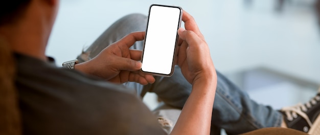 Foto chiuda sulla vista di un uomo che per mezzo dello smartphone dello schermo in bianco