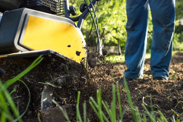 A close up view on motor cultivator during plow process spring season garden works concept