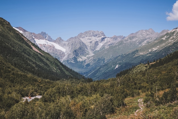 Vista ravvicinata delle montagne e delle scene fluviali nel parco nazionale di dombay, nel caucaso, in russia, in europa. paesaggio estivo, tempo soleggiato, cielo azzurro drammatico e giornata di sole