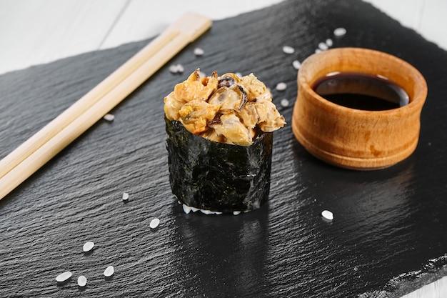 Close up view on nigiri sushi on slate plate isolated on white wooden background. japanese sushi food