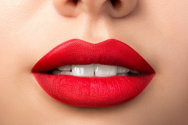 빨간 매트 립스틱으로 아름다운 여자 입술의 뷰를 닫습니다