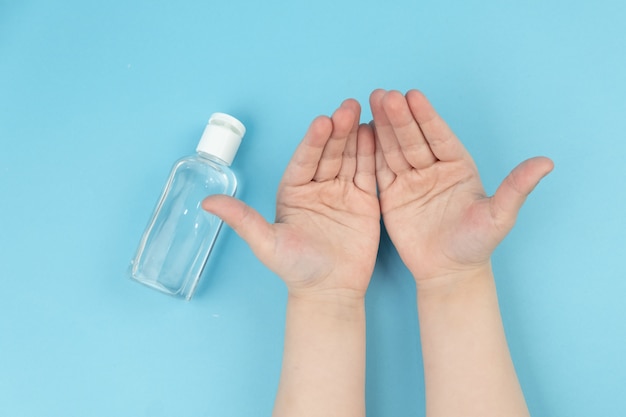사진 작은 휴대용 항균 손 소독제를 사용하여 어린이 손을 볼을 닫습니다. 바이러스 성 질병 예방