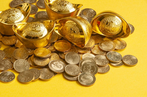 写真 黄色い表紙の背景にある金のインゴットと硬貨の近視