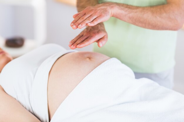 Фото Крупный план беременная женщина, получающая лечение рейки