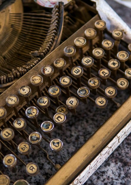 Photo close up view on an old dirty broken antique typewriter machine keys with cyrillic symbols letters