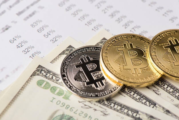 Immagine ravvicinata di bitcoin dorato e argento e mucchio di 100 dollari americani