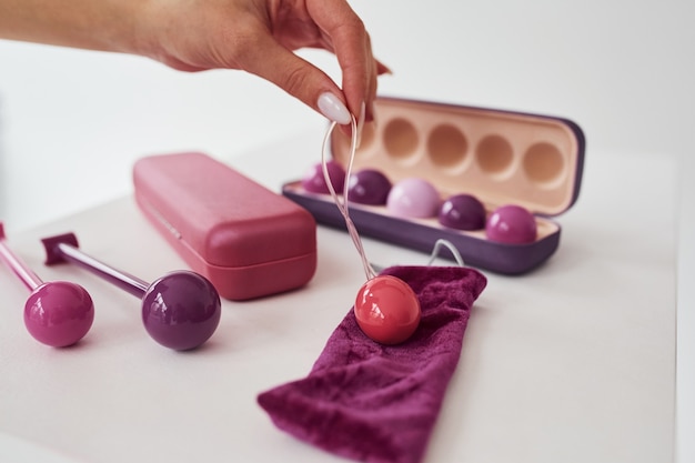 Close up view of pink vaginal balls and stimulators lying down on the table. Conception of imbuilding and woman health.