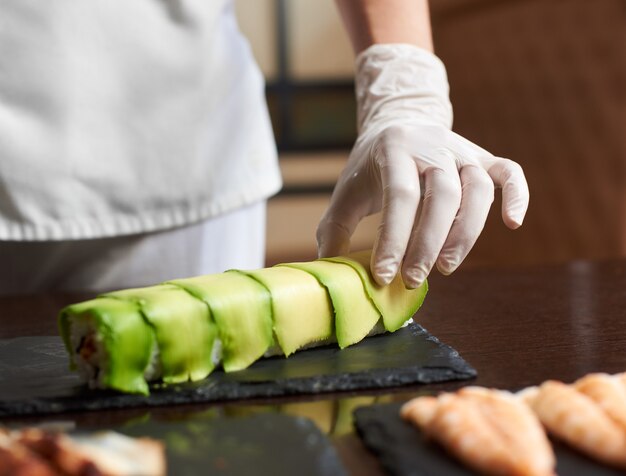 Close-up view of process of preparing rolling sushi