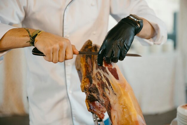 close up view of a professional ham cutter while cutting the ham and preparing the portions.