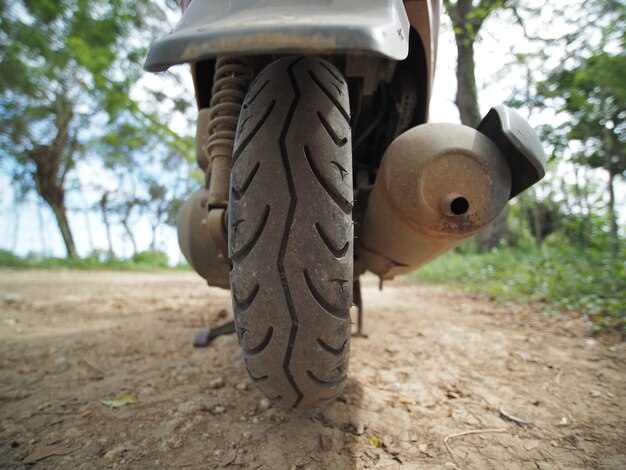 클로즈업보기. 비포장 도로에서 스쿠터 오토바이의 뒷 타이어.