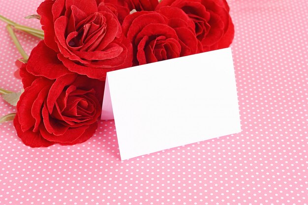 Foto chiuda sulla vista delle rose rosse con la carta del giorno di biglietti di s. valentino