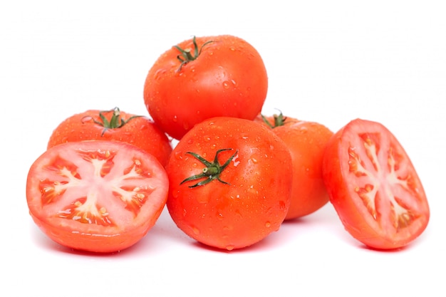 Close up view of red tomatoes with water droplets, isolated on a white background.