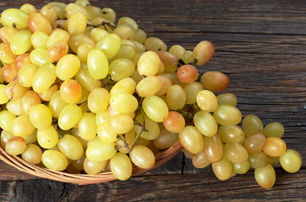 Close up view of ripe grape in basket on wooden table