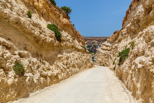 Close-up view of the rock formation. A desert trail among smooth polished stone walls.