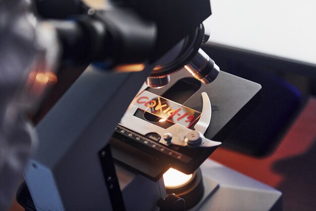 Close up view of scientist in protective uniform that works with coronavirus in laboratory