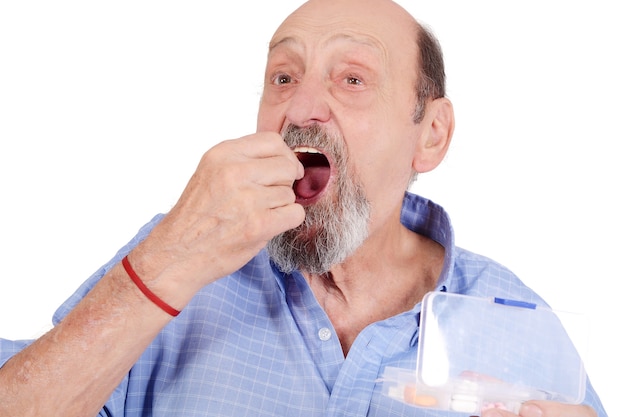 Close up view of senior man taking pill