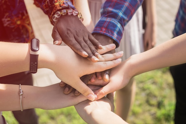 Close up view of six different hands putting together