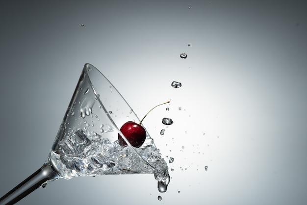 Close up view of splash water with falling cherry.