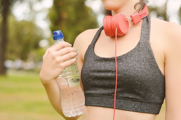 Close up view of sportswoman holding water after workout