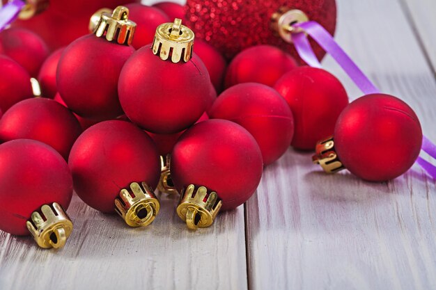 Close up view on stack of red christmas balls on wooden boards horizontal version