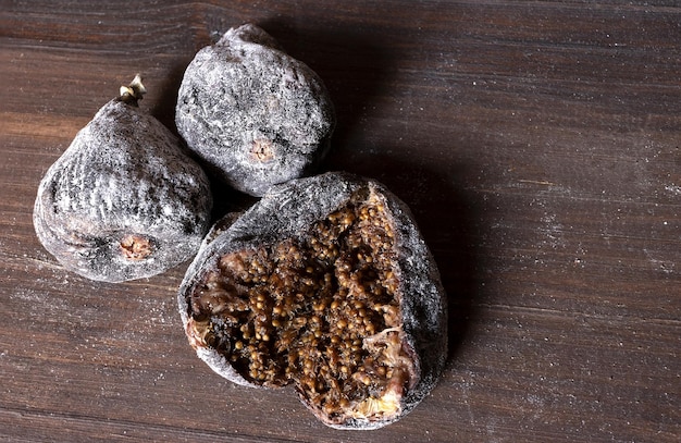 Close up view of three floured dried figs one of them open