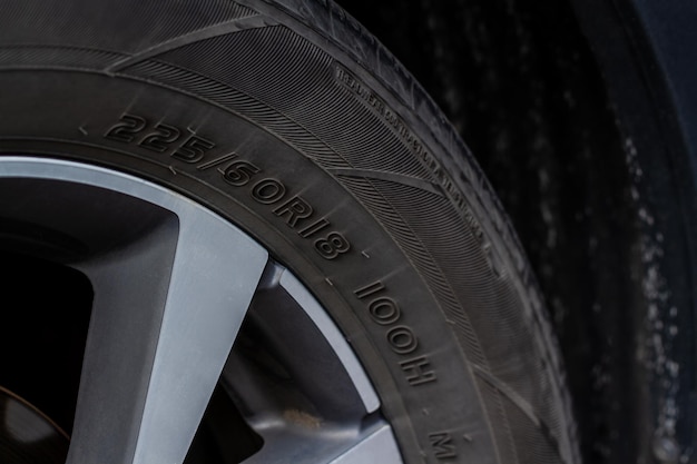 Close up view of tire with tire width, height and wheel diameter designation. Tire size types labels.