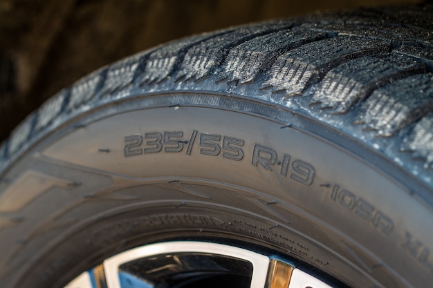 Close up view of tire with tire width, height and wheel diameter designation. Tire size types labels.