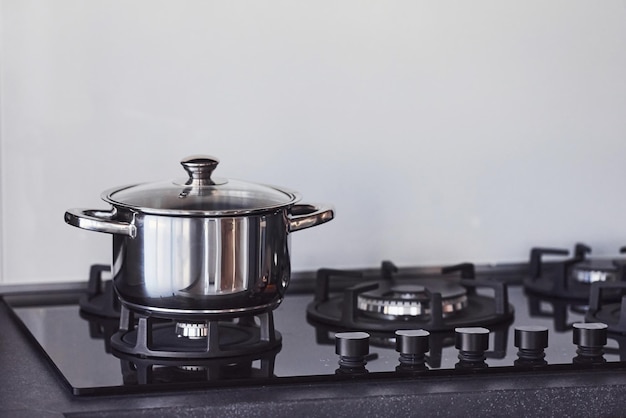 Close up view of top of a gas stove indoors near wall at daytime