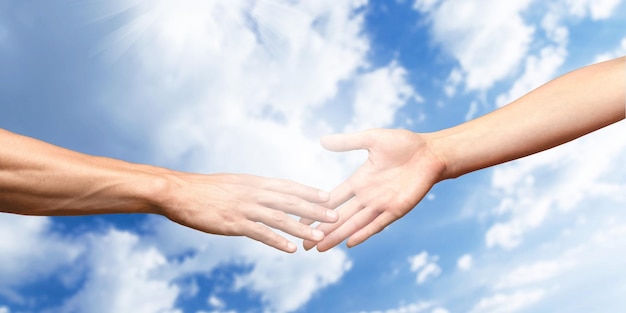 Close-up view of two hands on sky background