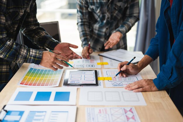 Close up view of UI developer team brainstorming on their project with laptop smartphone and digital tablet Creative digital development agency in office