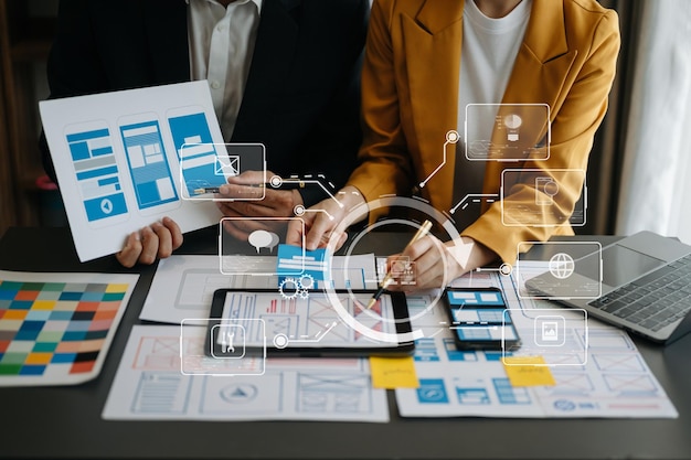 Close up view of UI developer team brainstorming on their project with laptop smartphone and digital tablet Creative digital development agency with virtual icons