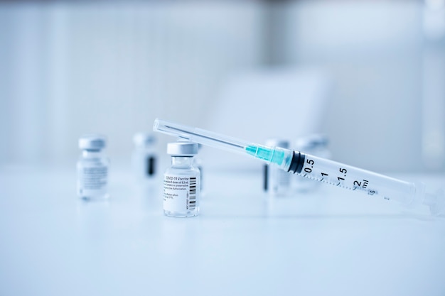 コロナウイルスまたはcovid19パンデミックを阻止するためのワクチンボトルと注射器の拡大図