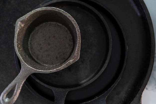 Close up view. Variety of cast iron frying pans on a marble background.