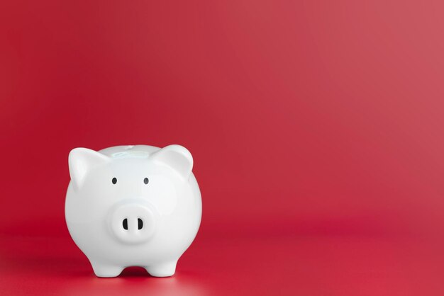 Close-up view of white candle against red background