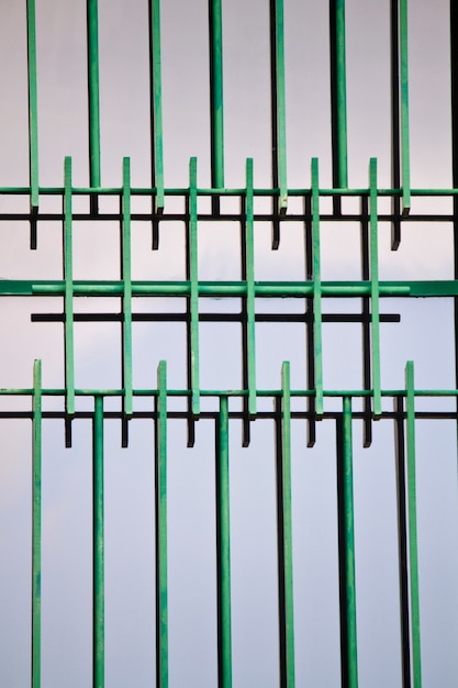 Close up view of a window with iron green bars.