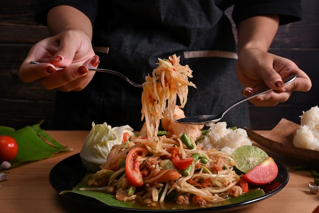 スパイシーなパパイヤサラダを食べる女性をクローズアップ。