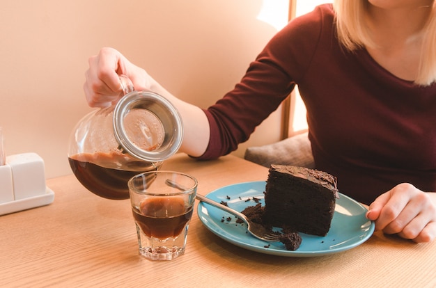 カップにコーヒーを注ぐ女性のビューを閉じます。ビジネスランチ