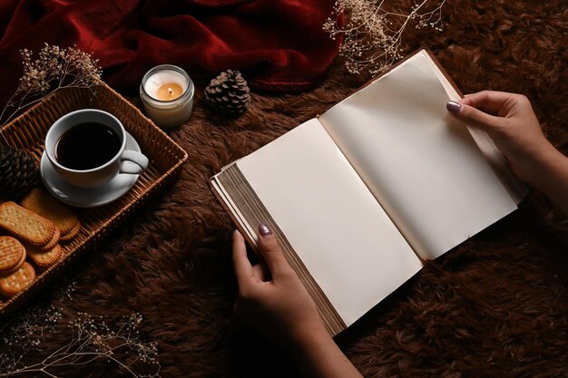 Close up view woman reading book on brown carpet.