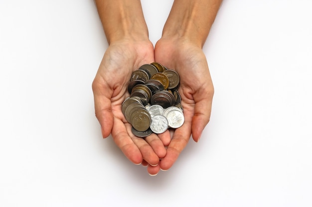 close up view of woman's hands with indian rupees coins on white background.
