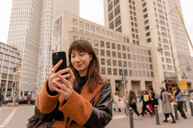 携帯電話で通りの笑顔の女性のクローズアップビュー