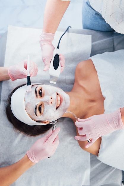 Close up view of woman that lying down in spa salon and have face cleaning procedure by different devices and mask.